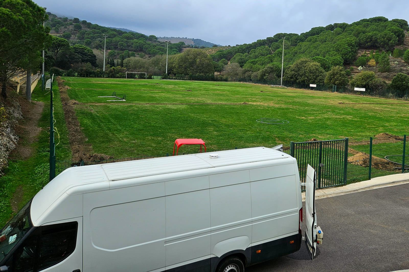 Fourgon de l'entreprise stationné sur un chantier, en bord de terrain