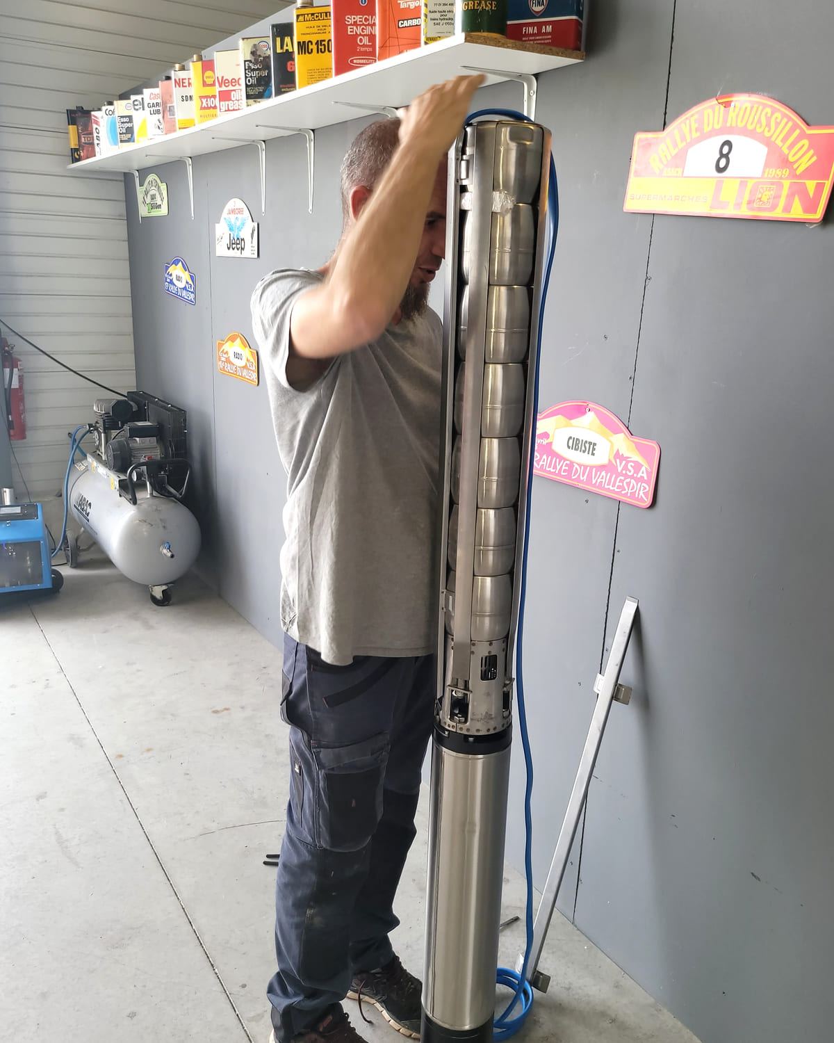 Technicien tenant une pompe immergée à la verticale dans l'atelier